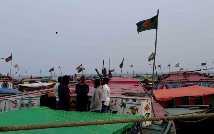 Des bateliers bangladais se tiennent sur leurs bateaux portuaires pour discuter de la situation due au faible niveau d’eau dans le fleuve Brahmapoutre. Photo : Shib Shankar Chatterjee.