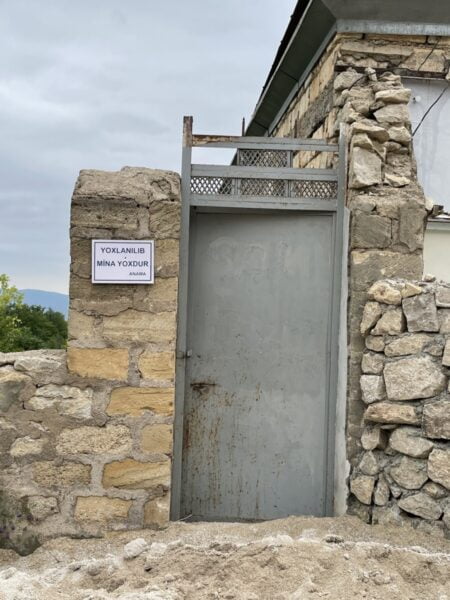 Une maison en ruine à Shusha, un panneau près de la porte indique débarrassé des mines terrestres. Photo : Nurit Greenger