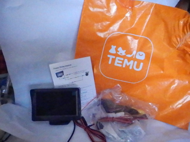 Image du système de caméra de recul de voiture et des sacs d’expédition TEMU orange distinctifs.